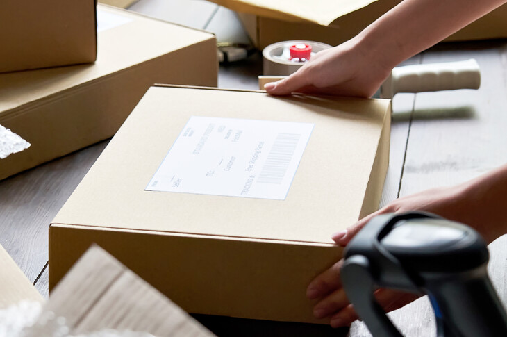 Versandservice Weibliche Lagerarbeiterin bereitet eine Paketbox für den Versand vor.