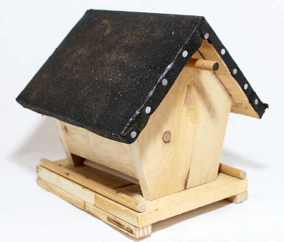 Ein Futterhäuschen für Vögel aus Holz.